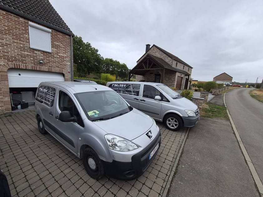 Les camionnettes CJM & FILS avec les logos de l’entreprise visibles sur les flancs