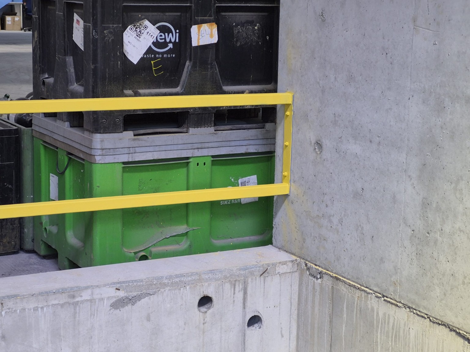 Barrière métallique jaune devant une zone de stockage